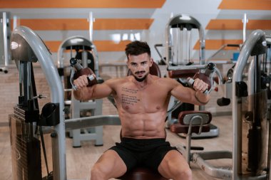 Spor salonunda spor yapmaya odaklanan kaslı sporcu vücut geliştirici spor modeli.
