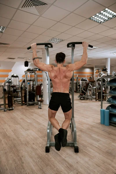 In een moderne sportschool gespierde man doet oefeningen voor zijn triceps geconcentreerd hard werken — Stockfoto