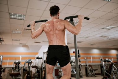Modern bir spor salonunda kaslı adam onun triceps için egzersizler yapıyor çok çalışma konsantre