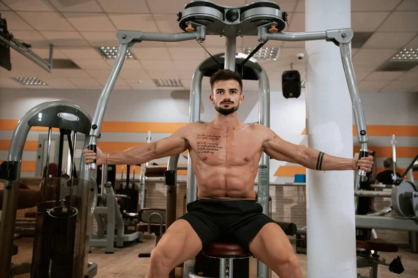 Muscular atlético jovem fisiculturista modelo de fitness com foco no exercício com no ginásio — Fotografia de Stock