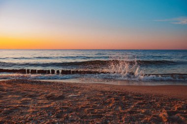 Mavi deniz kıyısındaki renkli gündoğumu manzarası