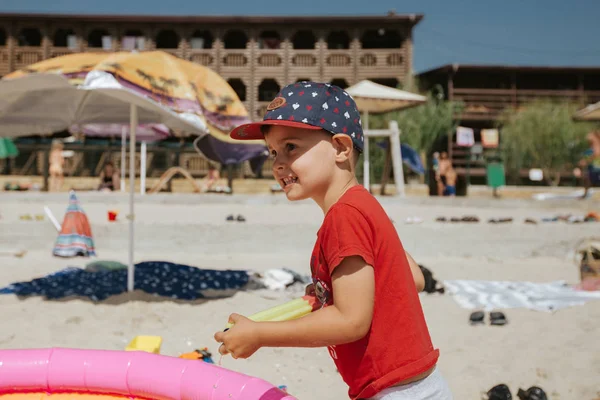 Lindo y sonriente niño jugando en la playa del mar —  Fotos de Stock