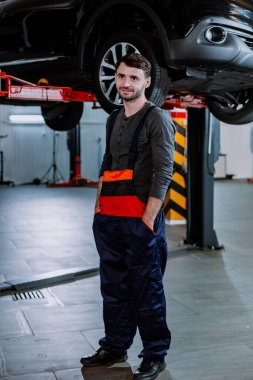 Modern bir otomobil hizmet merkezinde kameraya yakın mekanik adam karizmatik gülümseme şirin