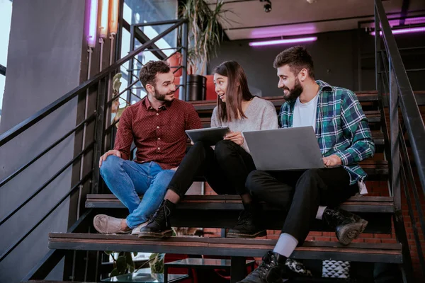 Closeup multiethnic students analyzing happy and excited their project for the college using a notebook they chatting with each other — Stock Photo, Image