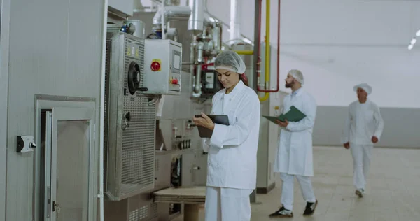 Sabah imalat sektöründe iki güzel mühendis sanayi makinesi kontrol ve elektronik tablet bazı notlar yapmak