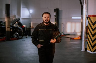 Modern bir otomobil hizmet merkezinde kameraya yakın mekanik adam karizmatik gülümseme şirin