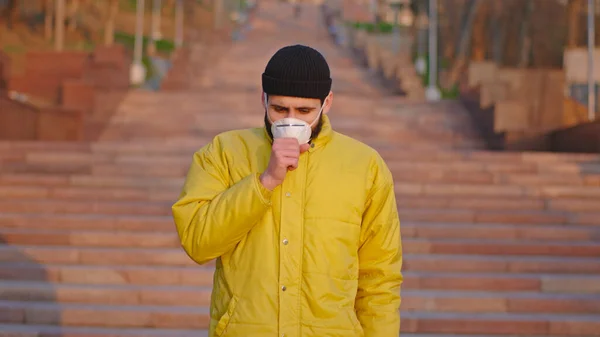 Young man outside coughing in the public he have a protective mask on his face N1H1 Coronavirus pandemic in China