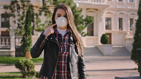 Korumacı maskeli, boş bir sokak kadınının ortasında insanlara koruyucu maske takmadan sokakta yürümemelerini önerirken Coronavirus... — Stok fotoğraf