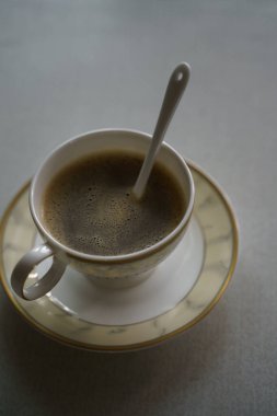 Hafif arka planda bir fincan kahve ve çay tabağı.