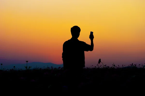Siluett av man poserar vid solnedgången himmel bakgrund. — Stockfoto