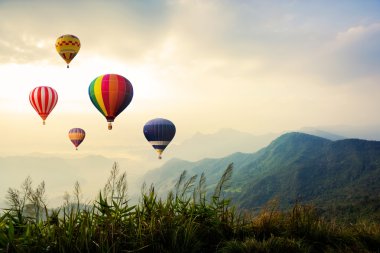 Dağların üzerinde uçan renkli sıcak hava balonları 