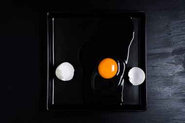 Yumurta ve kabuk siyah bir plaka üzerinde kırık