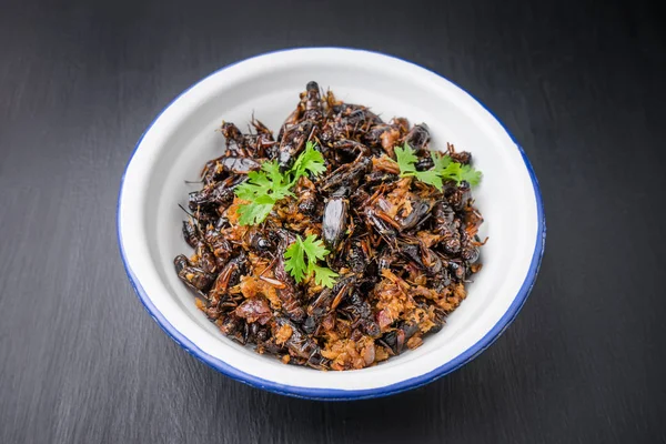 Food insect, Fried crickets in iron bowl on wooden table,