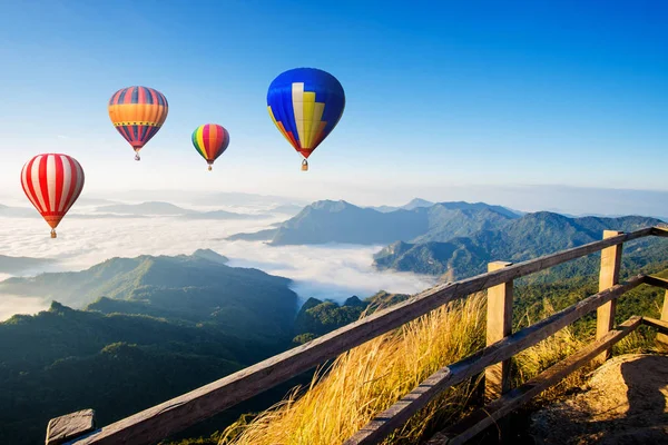 Kleurrijke hete lucht ballonnen vliegen over de berg — Stockfoto