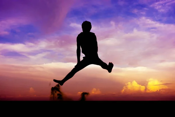 Silhouette man of having fun jumps on sunset — Stock Photo, Image