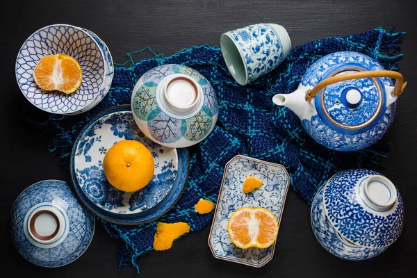 在黑色的早饭中规中矩的陶瓷板整体和片橘子水果 — 图库照片
