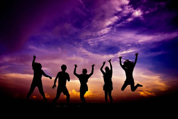 Silhouette group of friends having fun jumps on sunset — Stock Photo, Image