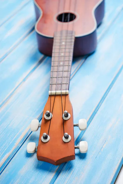 Close up of ukulele on blue wooden background — Stock Photo, Image