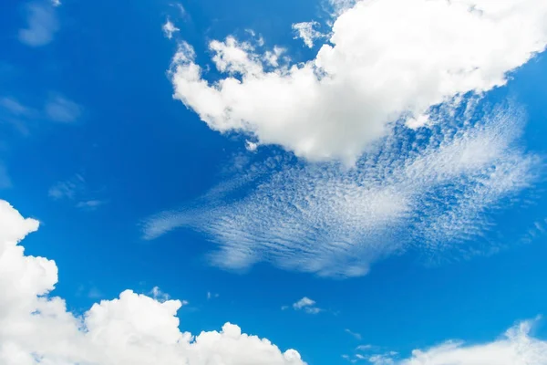 Modrá obloha pozadí s bílou nadýchané mraky — Stock fotografie