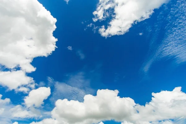 Modrá obloha pozadí s bílou nadýchané mraky — Stock fotografie