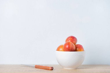 Masanın üzerine taze şeftali kase