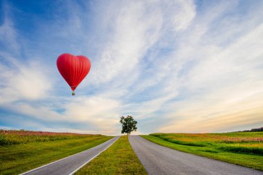 Günbatımında bir kalp şeklinde güzel kırmızı balon