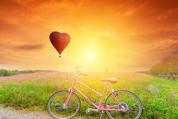 Όμορφο κόκκινο μπαλόνι σε σχήμα με τα ποδήλατα στο ηλιοβασίλεμα — Φωτογραφία Αρχείου