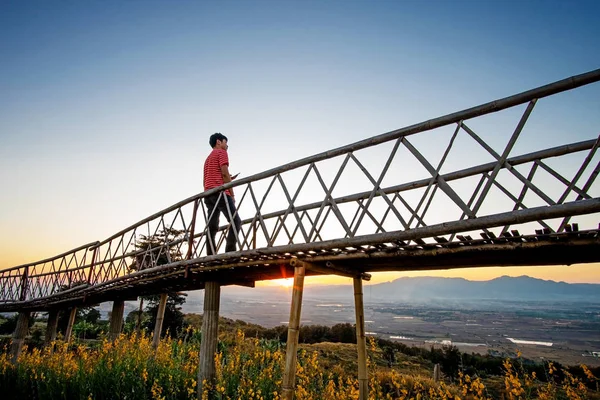 Silhueta de homem asiático em pé na ponte de bambu em Ban Doi Sa — Fotografia de Stock