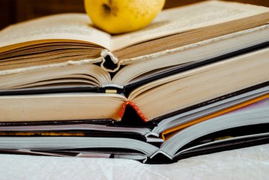 Yaşam Tarzı A beyaz arka planda bir yığın kitap. Sarı bir elma bir kitabın üzerinde yatıyor. Boşluğu kopyala
