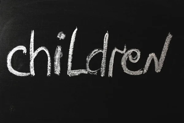 The word child written in white chalk on a black chalkboard