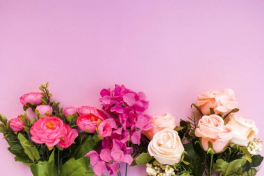 Pembe arka planda renkli çiçekler. Mesaj için yer. Şenlik arka planı. Olay. Konsept. Düz yatıyordu. Üst görünüm.