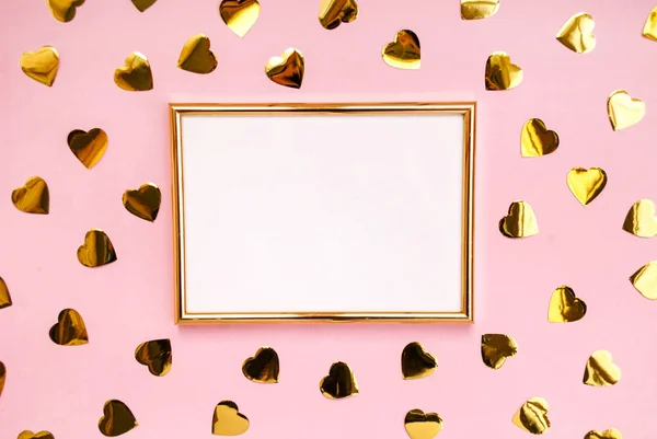 Gold frame on a pink background, confetti. Place for text. Festive background. Event. Birthday Conception. Flat lay. Top view.