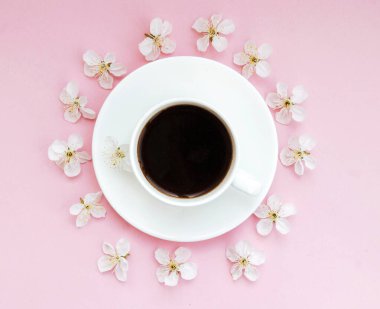 Bahar yerleşimi. Bir fincan beyaz kahve. Pembe arka planda beyaz çiçekler. Kart. Yaşam tarzı. İyi yapım. Moda fotoğrafı..