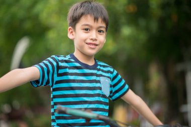 Küçük çocuk binicilik bisiklet evin etrafında yolda 