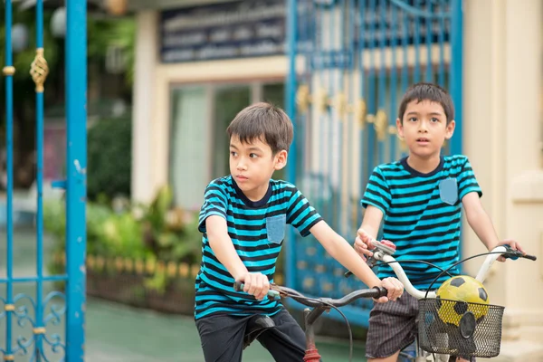 Menino andando de bicicleta na estrada em torno da casa — Fotografia de Stock