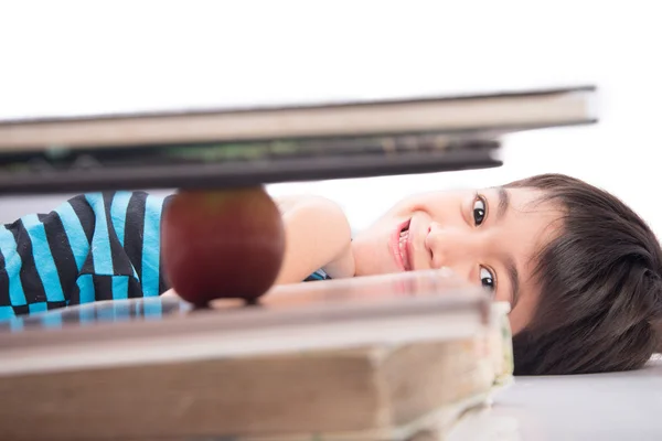 Маленький хлопчик дивиться на яблуко на концепцію освіти книги — стокове фото