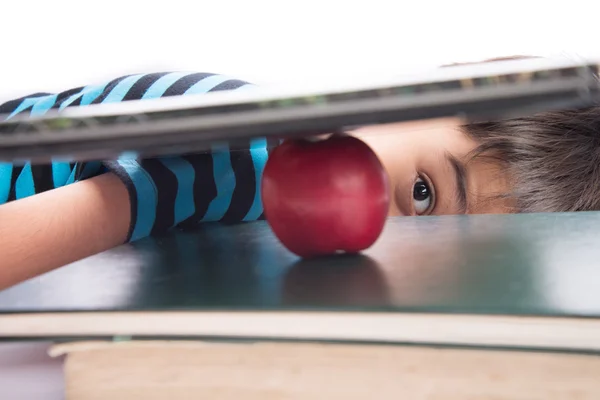 Niño mirando a una manzana en el concepto de educación libro —  Fotos de Stock