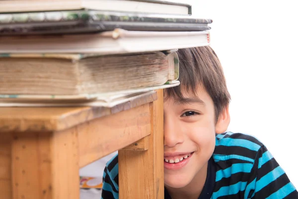 Kleiner Junge sitzt hinter dem Holzstuhl voller Bücher, pädagogisches Konzept — Stockfoto