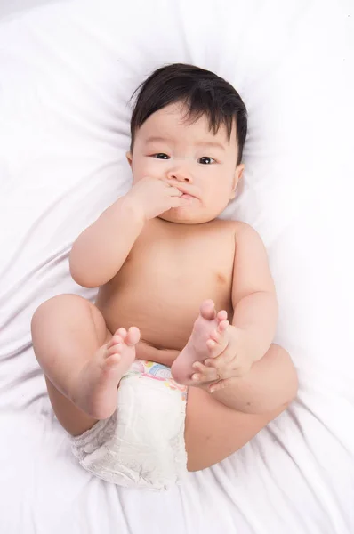 可爱的小亚洲男孩 6 个月大的白色的床上的肖像 — 图库照片