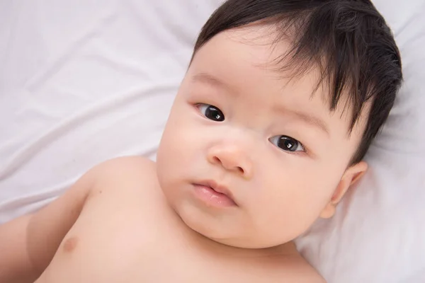 Retrato de bonito pouco ásia menino 6 meses idade no o branco cama — Fotografia de Stock