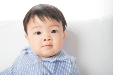 7 ay eski gülümseyen Asya bebek yüzünü kapatmak