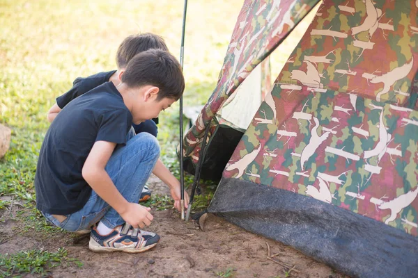 Маленький мальчик строит палатку для кемпинга с семейным отдыхом — стоковое фото