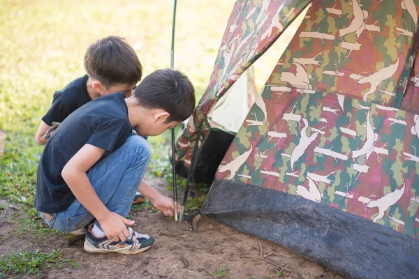 Liten pojke bygga ett tält för camping med familjesemester sommartid — Stockfoto