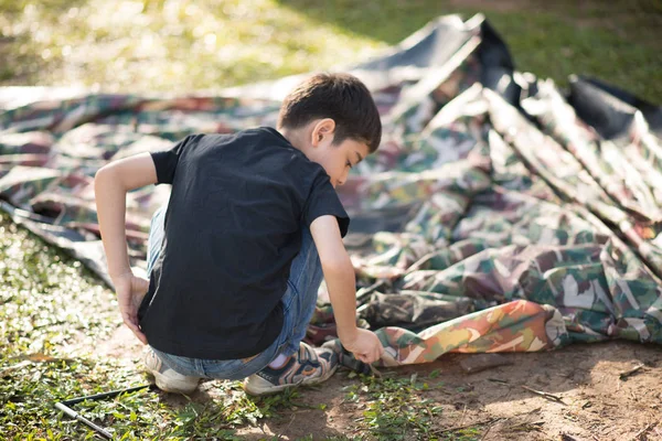 Liten pojke bygga ett tält för camping med familjesemester sommartid — Stockfoto