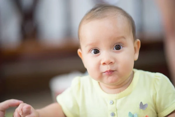 Detailní záběr 7 měsíců holčičku stojící s šťastný obličej — Stock fotografie