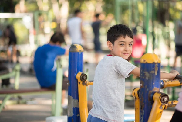 Kleiner Junge fährt Power-Gym-Fahrrad auf Spielplatz — Stockfoto