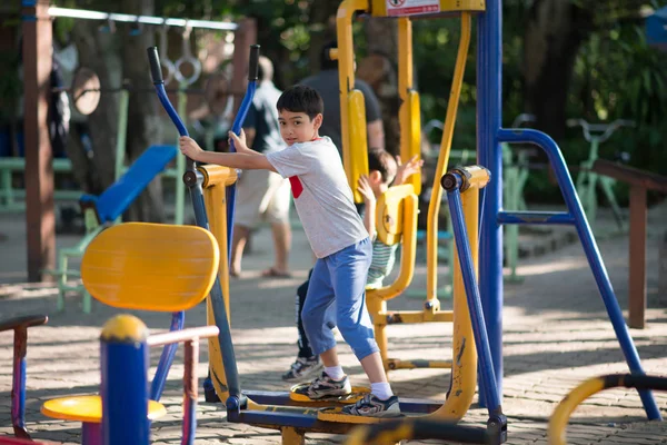 Kleiner Junge fährt Power-Gym-Fahrrad auf Spielplatz — Stockfoto