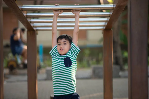 Kleiner Junge hängt auf Spielplatz an Stange — Stockfoto