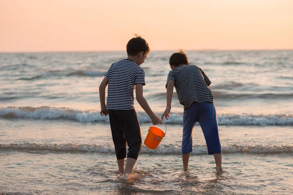 Petit garçon jouant au coucher du soleil sur la plage — Photo