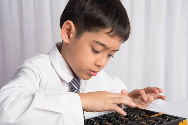 Niño pequeño usando ábaco para estudiar matemáticas clase de educación —  Fotos de Stock